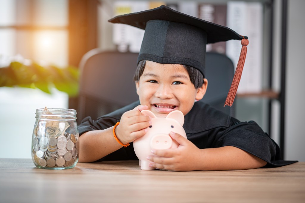 Child in cap saving for college through Life insurance for kids