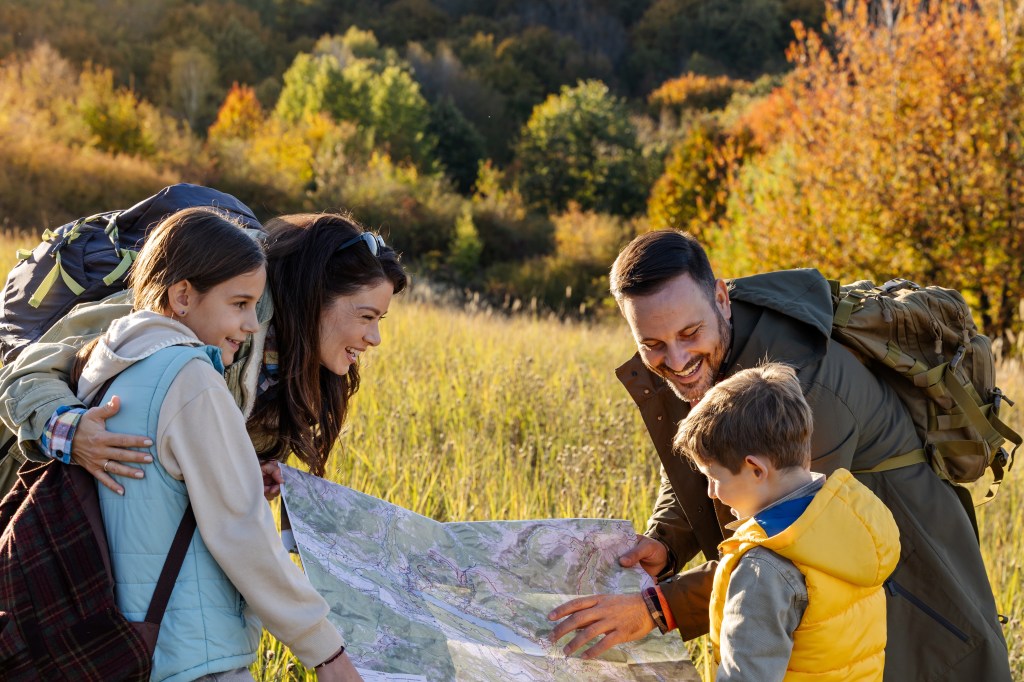 Family reading a map outdoors, symbolizing Generational Wealth guidance.