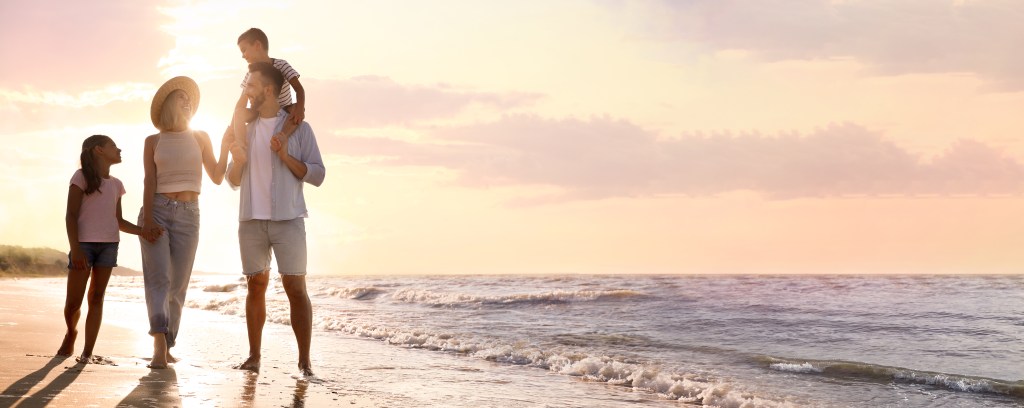 Happy family by ocean illustrating Generational Wealth across generations.